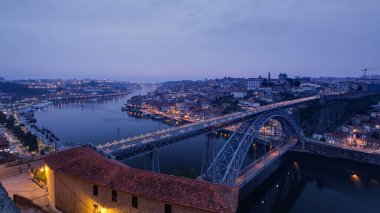 Day to night transition aerial panoramic view of the historic city of Porto, Portugal timelapse with the Dom Luiz bridge. Colorful sky after sunset