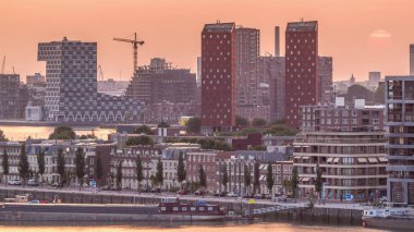 Hollanda, Rotterdam 'da gün batımında Katendrecht Yarımadası ve Maashaven Limanı' nın panoramik zaman çizelgesi. Şehir silueti, modern gökdelenler ve geleneksel Hollanda rıhtım evleri