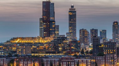 Rotterdam, Hollanda 'daki Katendrecht yarımadası ve Maashaven limanının hava ve gece geçiş zamanı. Şehir silueti modern gökdelenler ve geleneksel Hollanda rıhtım evleri