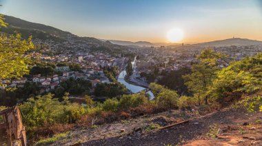 Saraybosna 'nın en popüler panoramik noktasından nehrin aktığı gün batımı manzarası. Sarı Kale (Zuta Tabija) yakınlarındaki yol, Vratnik