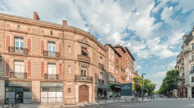 Panorama, Fransa 'nın Toulouse kentindeki Rue du Languedoc ve Theodore Ozenne kavşağında tarihi tuğla cephelerini gösteriyor. Canlı şehir merkezindeki Carmes metro istasyonu yakınlarındaki dükkanlar, kafeler, yol trafiği