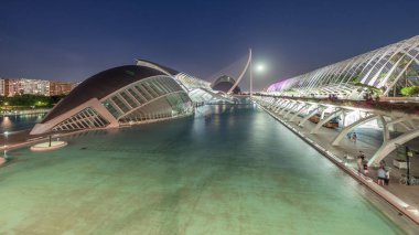 Valencia 'nın Sanat ve Bilim Şehri' nin, fütüristik mimari üzerine dolunay yansıması serin sulara yansıyan panoramik günden geceye geçiş zamanı. Büyüleyici bir İspanyol kültürel simgesi