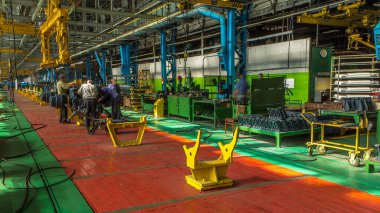 Konveyör montajı, traktörün gövdesini büyük endüstriyel fabrika zaman diliminde sahneleyecek. Çerçeve montajı, Chassis kurulumu ve diğer parçalar. Bir sürü işçi