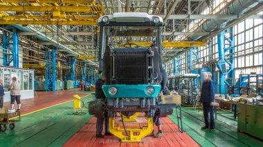 Konveyör montajı, traktörün gövdesini büyük endüstriyel fabrika zaman diliminde sahneleyecek. Çerçeve montajı, radyatör ve kabin kurulumu ve diğer parçaları olan motor.