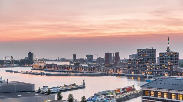 Rotterdam, Hollanda 'daki Katendrecht Yarımadası ve Maashaven Limanı' nın panoramik hava ve gece geçiş zamanı. Şehir silueti modern gökdelenler ve geleneksel Hollanda rıhtım evleri