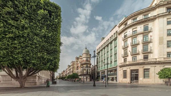 Avda boyunca yürüyen yayalar. De la Constitucion, Seville, İspanya 'nın Casco Antiguo bölgesindeki ana cadde. Edificio de la Adriatica ile zaman atlaması, tarihi binalar ve geçen tramvaylar
