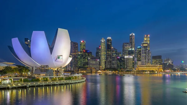 Futuristic architecture flower shape design of the Art Science museum day to night transition timelapse after sunset. Skyscrapers skyline city of Singapore.