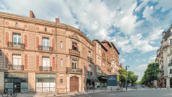 Panorama, Fransa 'nın Toulouse kentindeki Rue du Languedoc ve Theodore Ozenne kavşağında tarihi tuğla cephelerini gösteriyor. Canlı şehir merkezindeki Carmes metro istasyonu yakınlarındaki dükkanlar, kafeler, yol trafiği
