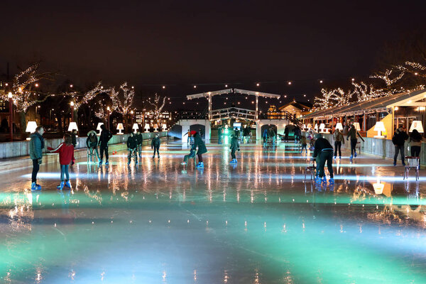 АМСТЕРДАМ, НИДЕРЛАНДЫ - 7 ЯНВАРЯ 2019 года: посетители на катке музей площади в Амстердаме ночью
 