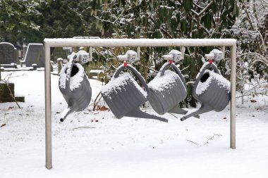 Sulama tenekeleri Belediye Mezarlığı'nda Amsterdam, Hollanda, asılı karda