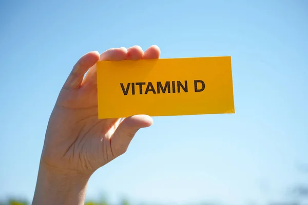 El D vitamini kağıdına güneşli mavi gökyüzü karşı tutar.