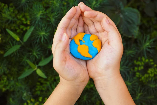 Dünya onun ellerinde tutan genç çocuk. Kavram görüntü.