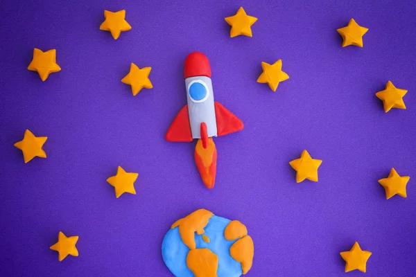 Uzay roketi yıldızlı gökyüzüne uçan. Uzay roketi ve dünya gezegeni (hamuru oyun çamurdan yaptım).