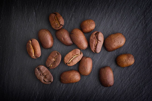 Grãos de café em fundo ardósia preta — Fotografia de Stock