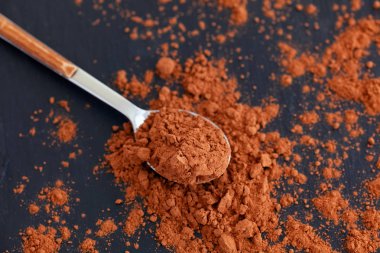 Kaşık organik kakao tozu ile dolu. Üstten görünüm. Doğal aydınlatma.