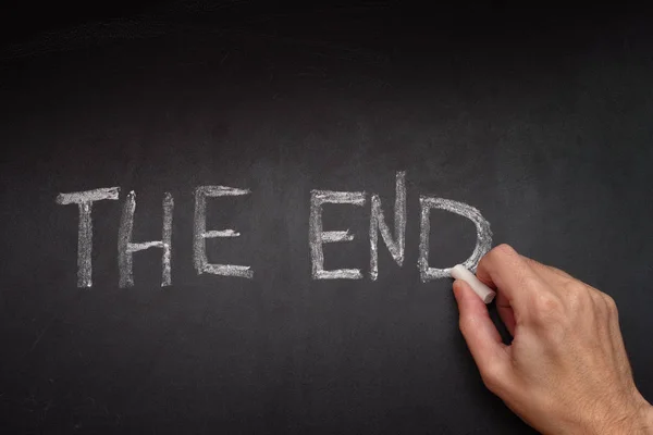 Man The End schrijven op blackboard — Stockfoto