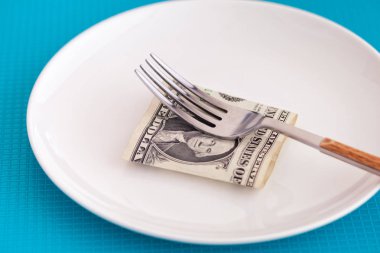 Bize bir dolar çatal ile bir tabakta. Yakın çekim.