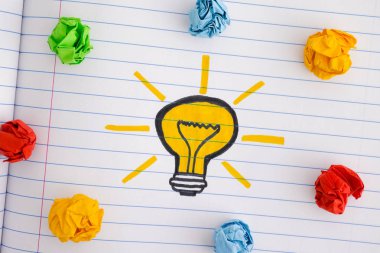 Çizim bir ampul ve renkli kağıt topları buruşuk. Yeni fikir kavramı. Yakın çekim.