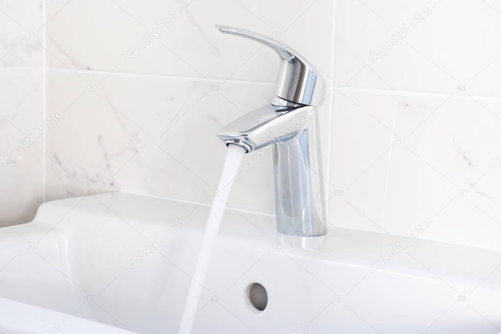 Faucet pouring water into sink