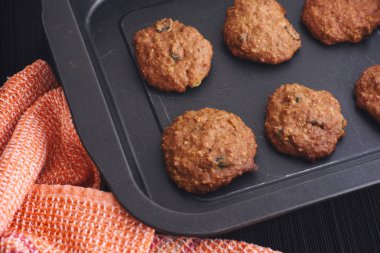 Fırın tepsisinde üzüm ile ev yapımı yulaf ezmesi kurabiye