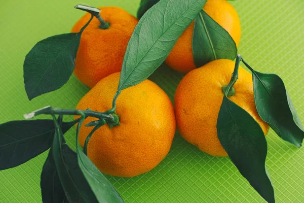 Fresh organic oranges with leaves on a green background — Stock Photo, Image