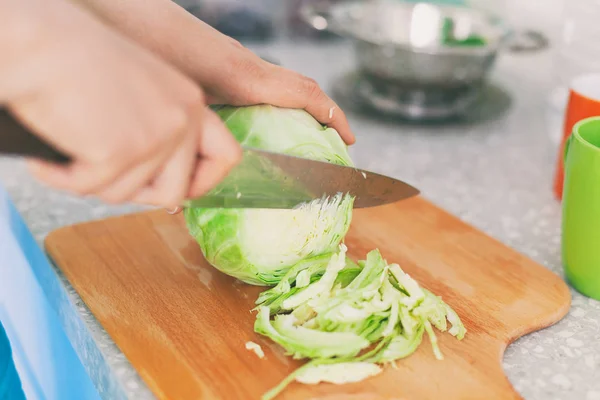 Το άτομο κόβει το λάχανο στην σανίδα κοπής στην κουζίνα — Φωτογραφία Αρχείου