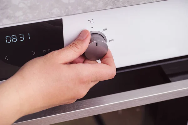 Person setting the temperature in celsius on the oven — Stock Photo, Image