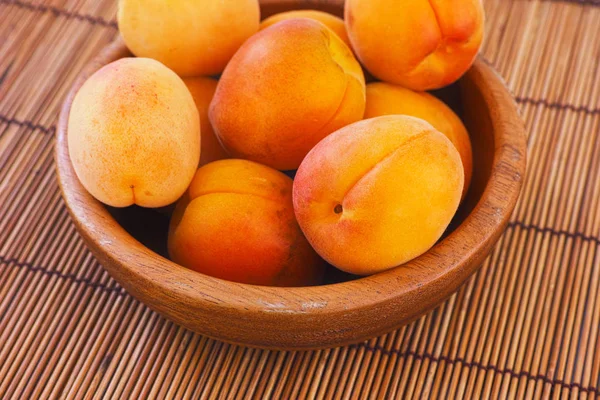 Organic apricots in a wooden bowl — Stock Photo, Image