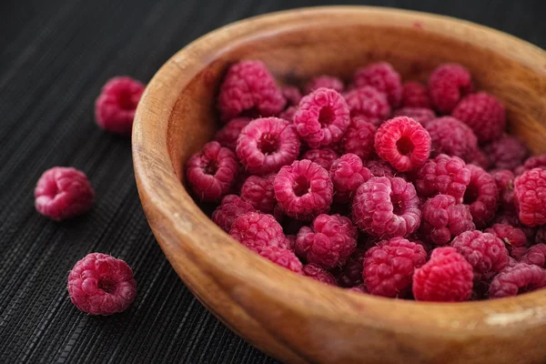 Ripe raspberries in a wooden bowl — Stock Photo, Image