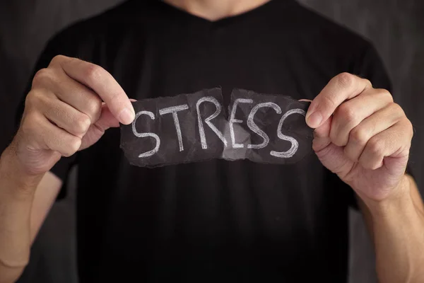 Hombre rasgando Palabra de estrés escrita en papel negro —  Fotos de Stock