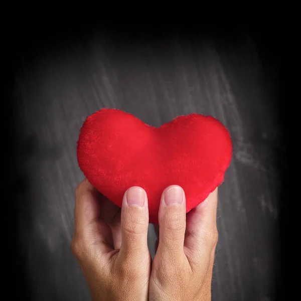 Człowiek posiadający czerwone serce w jego ręce — Zdjęcie stockowe