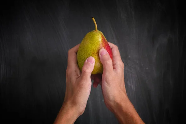 Man holding pear in his hands — Stock Photo, Image