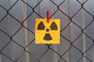 Radyasyon uyarı işareti metal bir örgü çit asılı