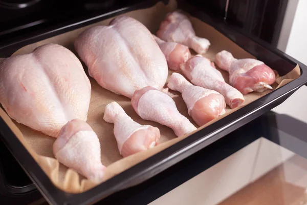 Chicken breast and chicken legs in a baking tray — Stock Photo, Image
