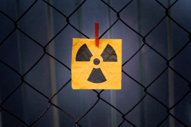 Radyasyon uyarı işareti metal bir örgü çit asılı