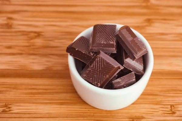 Gebroken donkere chocolade stukken in een kom — Stockfoto