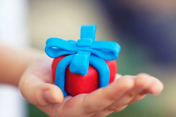 Young boy holds gift wrapped with blue ribbon. — ストック写真