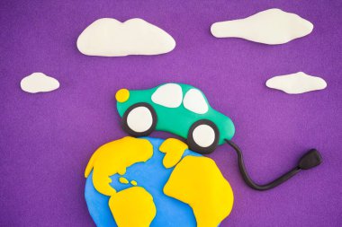 Dünya 'nın etrafında dolaşan elektrikli bir araba. Resmi Kabul Et. Sahne polimer kilden yapılmıştır..