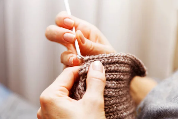 Closeup womans hands knitting wool yarn. Shallow focus.