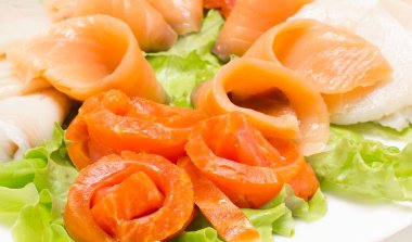 Beyaz tabakta limon ve sebzeli füme somon. Yiyecek konsepti.