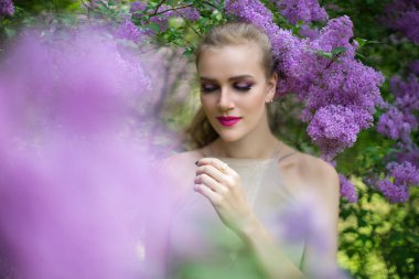 Bahar bahçe ayakta çiçek çiçeklenme tree yakınındaki güzel kız. Bush çiçeği Parkı moda elbiseli Genç kadın. Aromatik doğa kokusu alıyorum. Yatay fotoğraf afiş ücretsiz yer