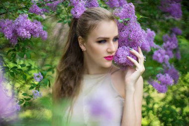 Bahar bahçe ayakta çiçek çiçeklenme tree yakınındaki güzel kız. Bush çiçeği Parkı moda elbiseli Genç kadın. Aromatik doğa kokusu alıyorum. Yatay fotoğraf afiş ücretsiz yer