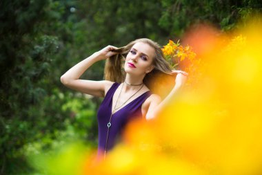 Bahar bahçe ayakta büyük çiçek çiçekli çalı yakınındaki güzel kız. Çiçek çiçek Parkı moda elbiseli bir genç kadın. Aromatik doğa kokusu alıyorum. Yatay fotoğraf afiş ücretsiz yer