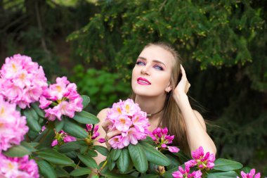 Bahar bahçe ayakta çiçek çiçeklenme tree yakınındaki güzel kız. Bush çiçeği Parkı moda elbiseli Genç kadın. Aromatik doğa kokusu alıyorum. Yatay fotoğraf afiş ücretsiz yer