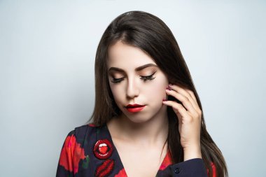 Retro tarzı makyaj, kavramsal fikir. Kahverengi gölgeler, canlı renkler grafik şekiller çizgiler, kozmetik boyalar, renkli mücevher kırmızı dudaklar. yakın çekim fotoğraf. sanatsal boya cilt. mükemmel gülümseme kırmızı dudaklar