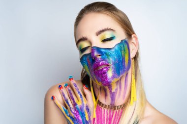 Yeni makyaj evren kadının yüzünde boyanmıştır. Alin kaşları gözleri şık akşam makyaj yeşil renkli, dalgalı bir çizgi yüz iki parçaya böler. Yüzünün alt kısmında akarsu canlı boya vardır.