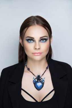 Genç kız güzel bir ceket bir sutyen genel gider askıları ile giydi. Sıkı bir şekilde bağlı saç ve iki iplikçik yayımladı. Smokey, çıplak ruj, doğal dudak bej dudak etkileyici akşam makyaj mavi gözler