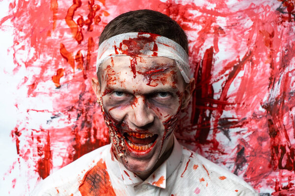 Crazy zombie horror make up. Person in white shirt with bloody sweat. Scars, deep scratches realistic art make-up. head is re-banded bandage, beaten with a stick. Horizontal banner for Halloween party