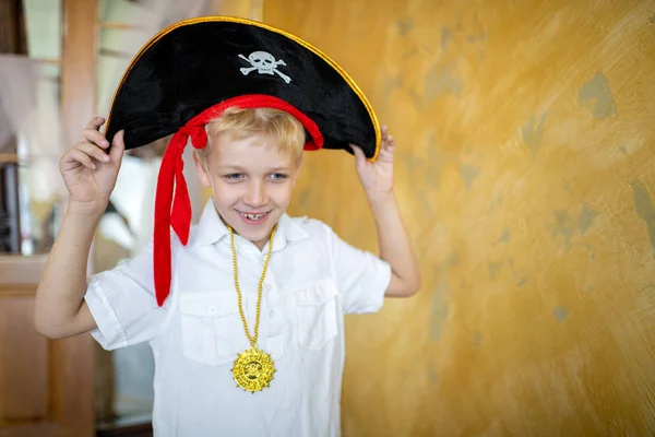 Boy pirate preparing for the holiday Halloween. Big pirate hat captain of a ship, male role play at a costume party children's holiday. Fun and emotions for a good mood. Studio wall horizontal banner