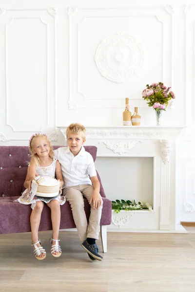 Niedlichen Kleinen Jungen Und Schönen Mädchen Sitzen Auf Einem Stuhl — Stockfoto